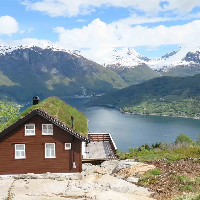 Utsikt over fjord og brun hus
