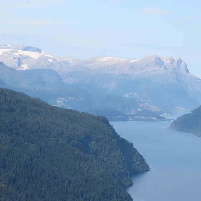 Grønn og frodig fjelldal med utsikt over fjorden i Olden.