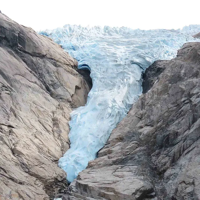 Nærbilde av en massiv, blåis-bre som ligger klemt mellom grå, bratte fjellsider.