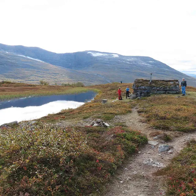 En steinete sti som fører mot en liten steinbu på høyfjellet i Olden.