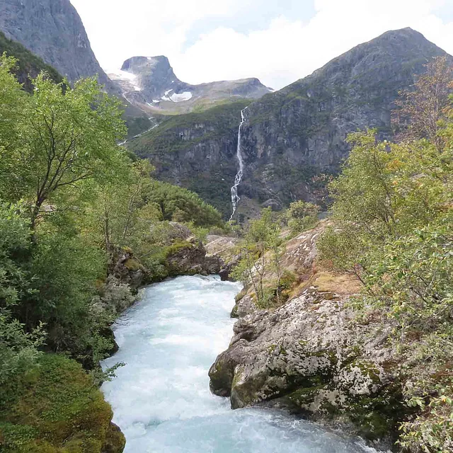 En vill og skummende elv som renner gjennom en trang fjelldal.