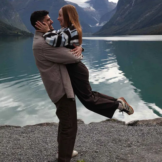 Mann som løfter sin forlovede ved fjorden.